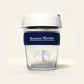 Unseen Worlds glass KeepCup with white lid, navy band with the wordmark and the twin-face logo, front view