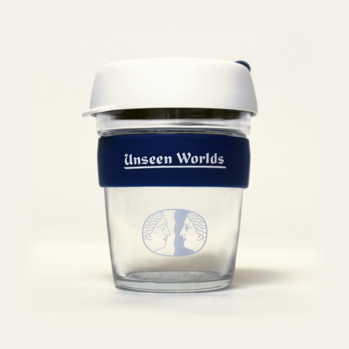 Unseen Worlds glass KeepCup with white lid, navy band with the wordmark and the twin-face logo, front view