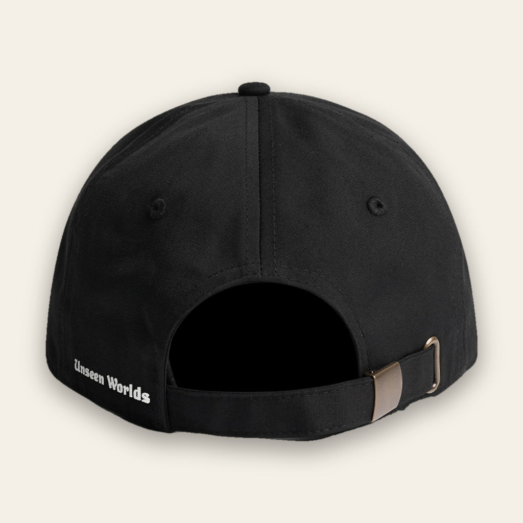 Back of the black Mystery Logo cap showing the embroidered Unseen Worlds wordmark on the rear-left panel and the adjustable strap
