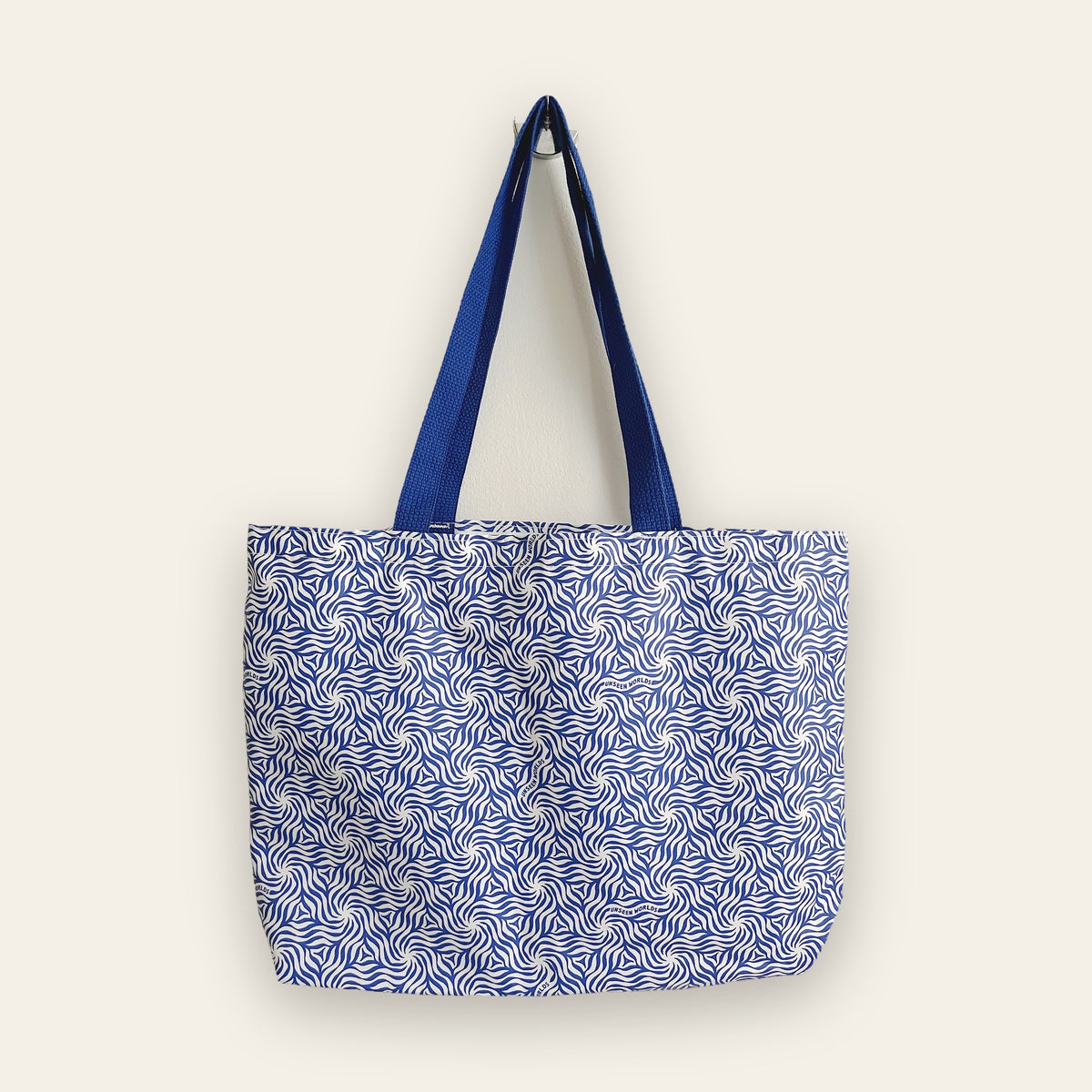 Unseen Worlds pattern tote bag in blue and white with navy handles